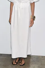 Falda midi blanca de lino, con cintura elástica ajustable con cordones y corte evasé.