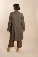 Camisa larga color crema con rayas verticales finas en gris, con botones dorados y bolsillo plaque en la delantera.