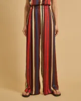 Pantalón de pinzas de talle alto con cintura elástica, bolsillos delanteros y pierna recta. Diseño a rayas verticales en tonos rojo, azul, beige y marrón.