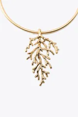 Collar rígido metálico tipo choker color dorado, con colgante en forma de coral en relieve.