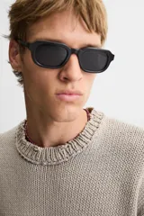 Jersey de punto color beige, de corte holgado, con cuello redondo y manga larga. Tiene efecto lavado y rotos en toda la prenda.