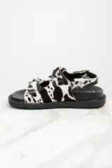 Sandalias con plataforma de goma negra y tiras de pelo de vaca con hebillas plateadas.