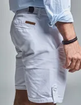 Bermuda color beige con cinturón, corte regular fit, dos bolsillos delanteros, dos traseros, un bolsillo relojero y botamanga con presilla. Aplique de badana.