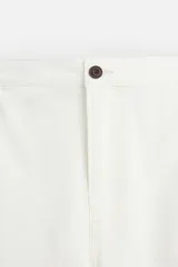 Pantalón de jean blanco, corte recto, con bolsillos frontales y traseros tipo parche.