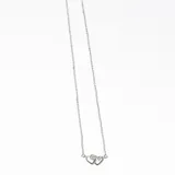 Collar plateado con cadena fina y dije de dos corazones entrelazados.