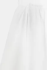 Pantalón blanco de tiro alto con cintura elástica ajustable mediante lazada interior. Presenta bolsillos laterales y un bajo con mucho volumen.