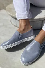 Slippers de cuero celeste con elásticos laterales y suela de goma blanca.