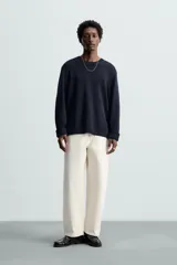 Jersey azul marino de punto, con cuello redondo y manga larga. Tejido en hilatura con mezcla de seda y lino.