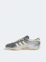 Zapatillas Adidas Tokyo color plateado con las tres tiras laterales en color crema.