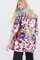 Saco de lentejuelas multicolor con forrería interna y largo a la cadera. Presenta un diseño abierto con mangas tres cuartos y una base de poliéster con forro de viscosa.