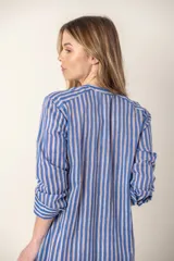 Vestido largo camisero a rayas verticales azules y blancas, con cuello mao, abotonadura frontal completa, mangas largas y bolsillos laterales.