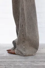 Jean de mujer color gris con efecto acid wash, de corte recto y tiro alto. Incluye bolsillos traseros y etiqueta de marca blanca en la cintura.