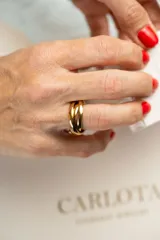 Anillo dorado de acero quirúrgico con tres aros entrelazados.
