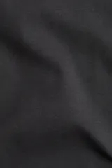 Remera negra de punto de algodón tupido con cuello redondo ribeteado acanalado.