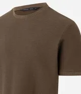 Remera de mangas cortas color crema, confeccionada con 50% algodón y 50% poliéster, con cuello redondo y tejido texturizado.