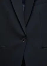 Americana de traje entallada color negro, de manga larga, con solapas con muesca, forro interior, detalle de pinzas, abertura posterior, hombros estructurados y dos bolsillos de ribete en la parte delantera.