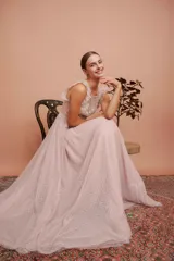 Vestido largo de fiesta color rosado con lunares blancos. Tiene cuerpo de micro tul bordado con volados en los hombros y falda de tul con forro. Incluye cinturón de raso al tono.