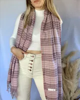 Pashmina de tejido suave en color rosa con patrón de cuadros y flecos.