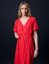 Vestido largo de gasa color rojo, con escote en V, mangas cortas con volados, cintura elastizada con lazo de ajuste y ruedo asimétrico con volados. Tiene forro interno a tono.