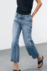Pantalón de jean celeste de tiro bajo, corte flare, cropped y cinco bolsillos.
