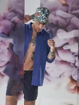 Gorro tipo bucket con estampado de hojas en tonos verde, amarillo y blanco.