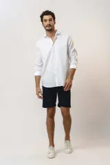 Camisa blanca de manga larga con cuello clásico y cierre frontal con botones.