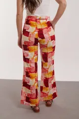 Pantalón de corte amplio con estampado de flores en tonos grises, amarillos y rosados.