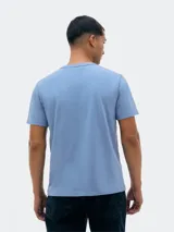 Camiseta de manga corta color ladrillo con cuello redondo y estampa cuadrada con paisaje de montañas en el pecho.