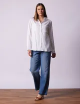 Camisa marrón de lyocell, marca Dash. Cuello con solapa y abertura central con botones. Largo de manga regulable con presilla y botón. Delantera con bolsillos aplicados.