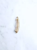 Broche dorado para el cabello con diseño texturizado.