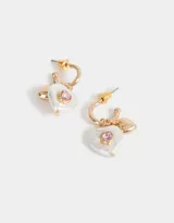 Aros argolla dorados con dije de perla blanca en forma de corazón y strass rosado.