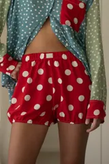 Short rojo con estampado de lunares blancos, de tiro medio y corte relajado, con cintura elástica y ruedo levemente fruncido.