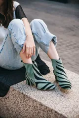 Botines de cuero con estampado de cebra en tonos verde claro y negro, con puntera fina y tacón cuadrado. Presentan paneles laterales elásticos en color verde liso.