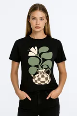 Remera blanca de algodón con estampado de flores azules y naranjas, de corte clásico y cuello redondo.