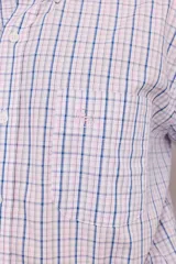 Camisa de manga larga con estampado a cuadros en tonos azul, gris y blanco. Tiene cuello abotonado, bolsillo en el pecho y corte clásico.