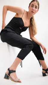 Sandalias de cuero negro con dos tiras, una sobre los dedos y otra al tobillo con cierre de velcro. Tacón bloque bajo.