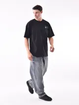 Remera blanca de corte oversized con logo pequeño estampado en el pecho.