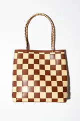 Bolso tipo tote de cuero tejido a mano con diseño a cuadros en color negro y tostado.