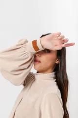 Polera de plush color blanco con cuello alto y mangas largas abullonadas.