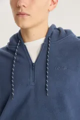 Buzo azul de polar con capucha, cierre parcial con cremallera, bolsillo tipo canguro y logo bordado en el pecho.