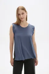 Remera azul de viscosa con cuello redondo y mangas cortas con volados. Corte holgado y largo a la cadera.