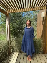 Vestido camisero amplio y largo de lino color azul, con botones de nácar, cuello camisero y bolsillos laterales.