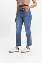 Jean straight de tiro medio, color azul denim, con corte recto y ruedo desflecado.