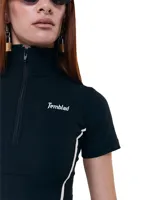 Top cropped negro de gabardina elastizada, con cuello alto, cierre frontal, silueta entallada, recortes y costuras a contratono.