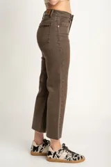 Pantalón jean marrón de corte flare, tiro medio y terminación desflecada.