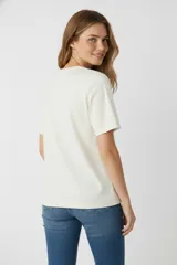 Remera negra de algodón con estampado de un corazón con palmeras, estrellas y flores.