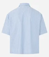 Camisa masculina oversized boxy de manga corta, confeccionada en tejido oxford a rayas verticales celestes y blancas. Cuenta con cuello inglés, abotonadura frontal y bolsillo de parche en el pecho.