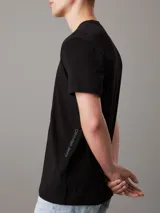 Remera negra de algodón con cuello redondo y mangas cortas. Cinta con logo de Calvin Klein Jeans en espiguilla en los laterales.