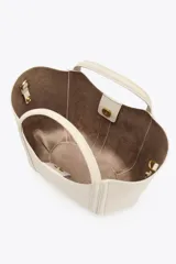 Bolso mini city color marrón con asa de mano y asa bandolera extraíble. Incluye bolsa interior extraíble con cierre mediante cremallera.