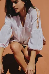 Blusa blanca boho con escote en V y bordados, de manga larga y diseño suelto.